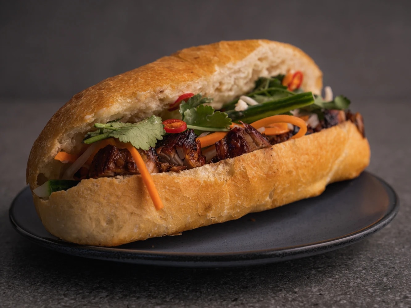A perfect fusion of crispy French baguette filled with savory meats, pickled vegetables, herbs, and spicy sauces, offering a delightful crunch and flavor 